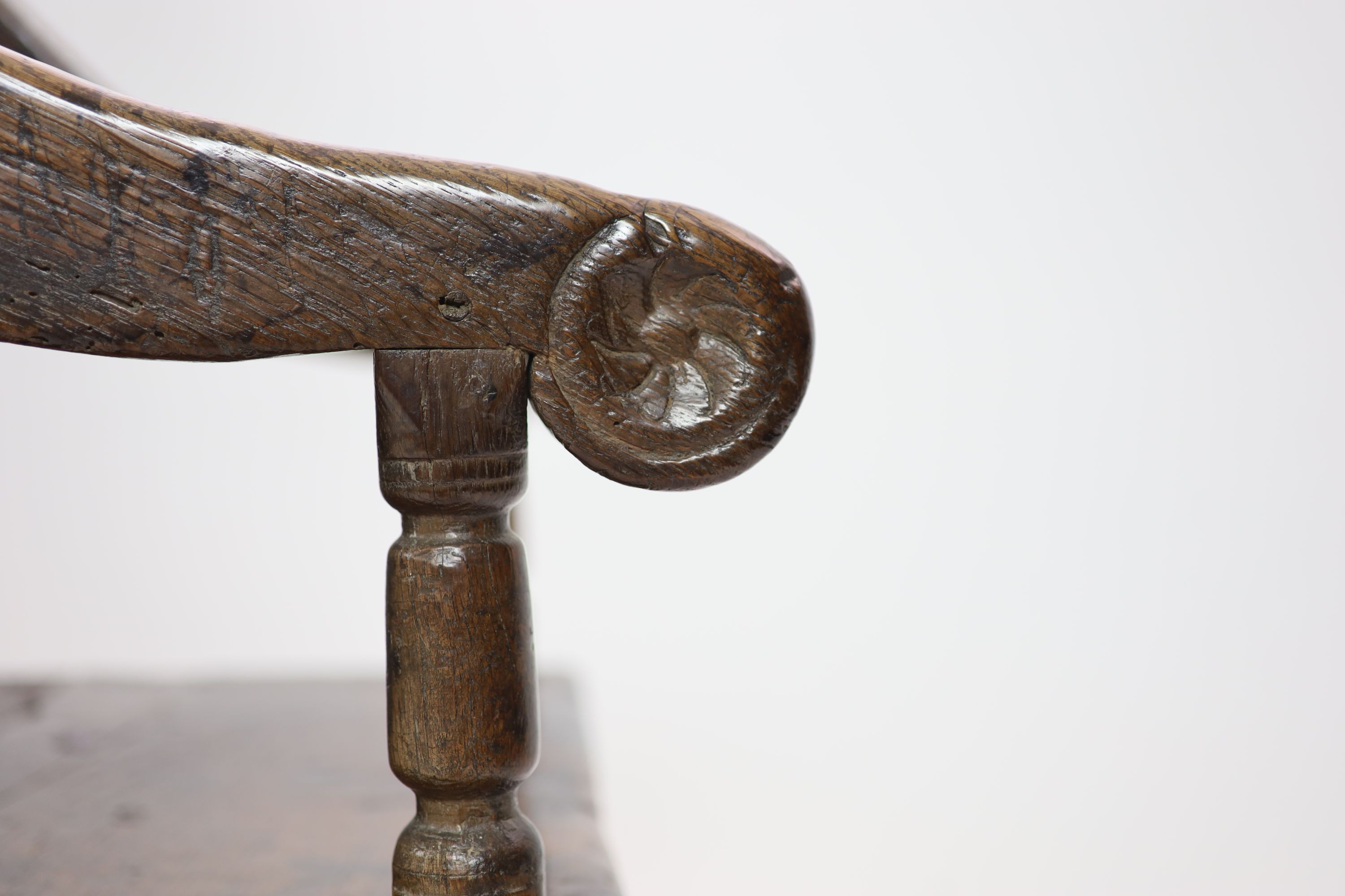 A 17th century panelled oak open armchair, the seat initialled 'PO' H 97cm. W 66cm. D 52cm.
